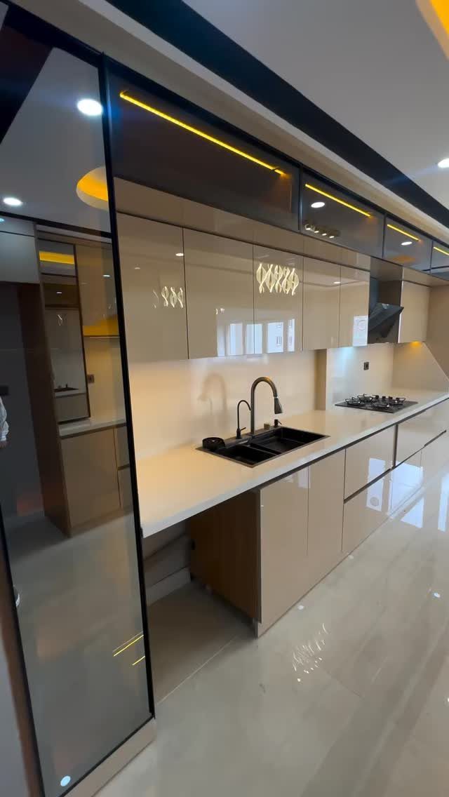 Nigerian Kitchen Design: 25 Ideas for Modern Functional Spaces 24 Modern kitchen with glossy beige ceiling-height cabinets and integrated yellow LED strip lighting.