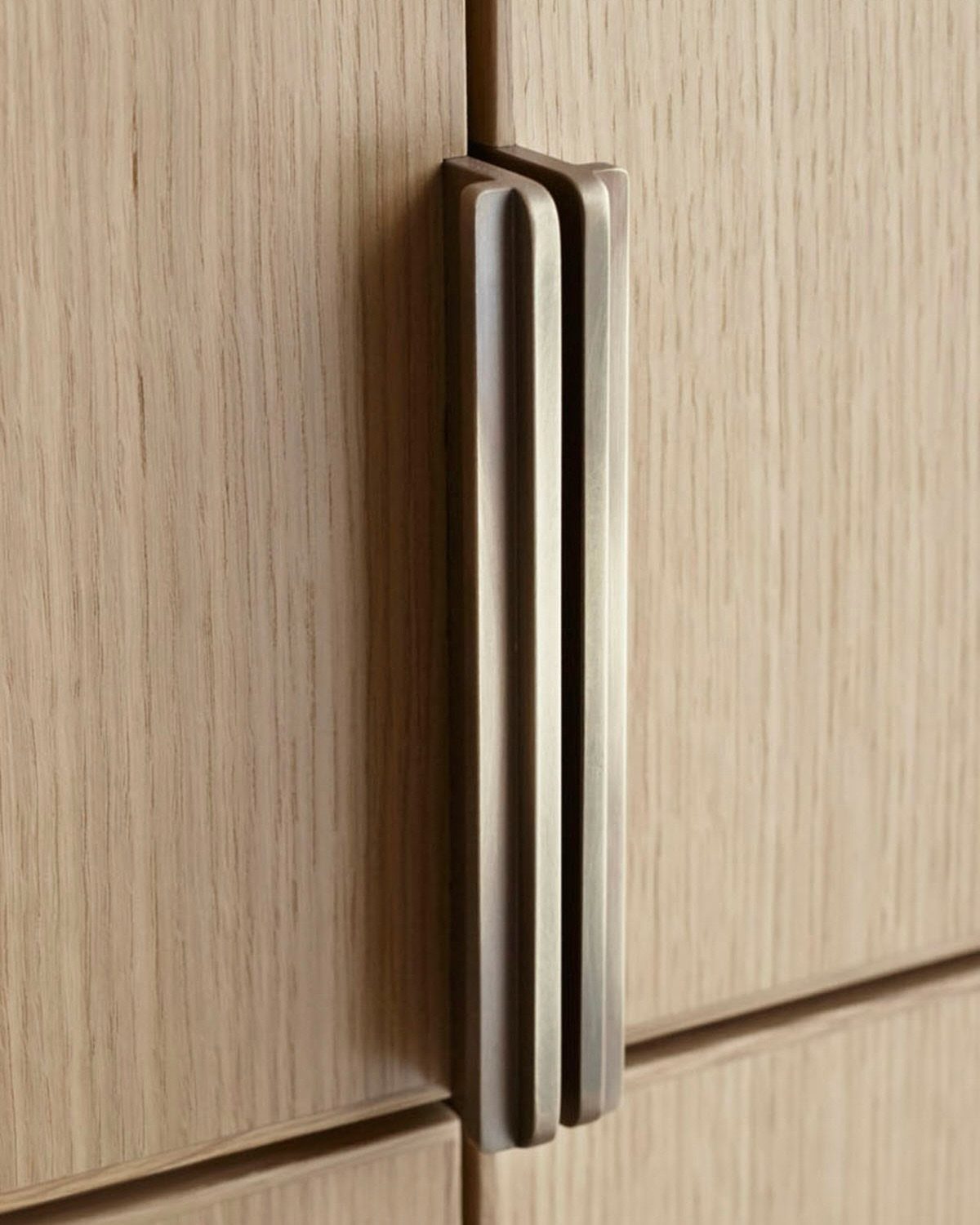 12 Kitchen Cabinet Handles Ideas to Refresh Your Space 10 Brushed antique brass rectangular cabinet pulls on light wood grain kitchen cabinets.