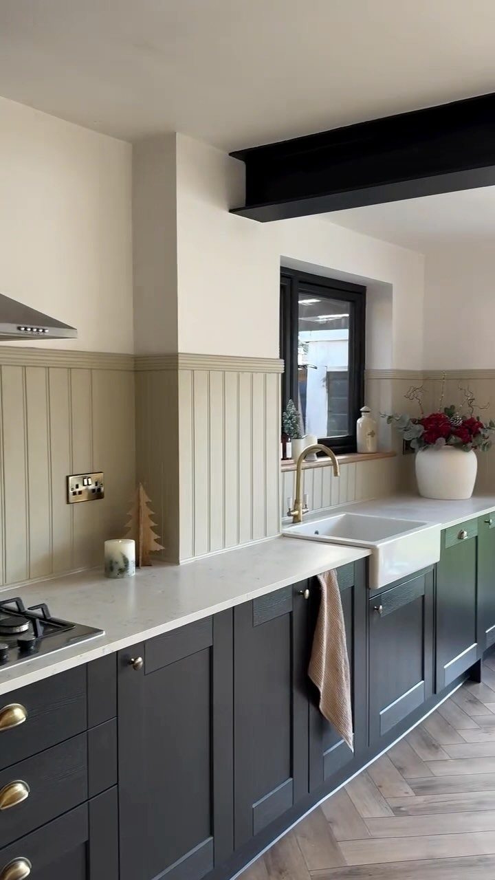 Dark grey shaker cabinets with gold hardware and a white farmhouse sink.