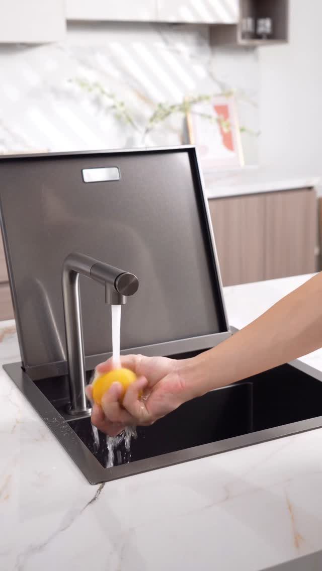 Small Kitchen Sink Ideas: 26 Ways to Maximize Space and Style 26 Small black square kitchen sink with a person washing a lemon under the faucet.