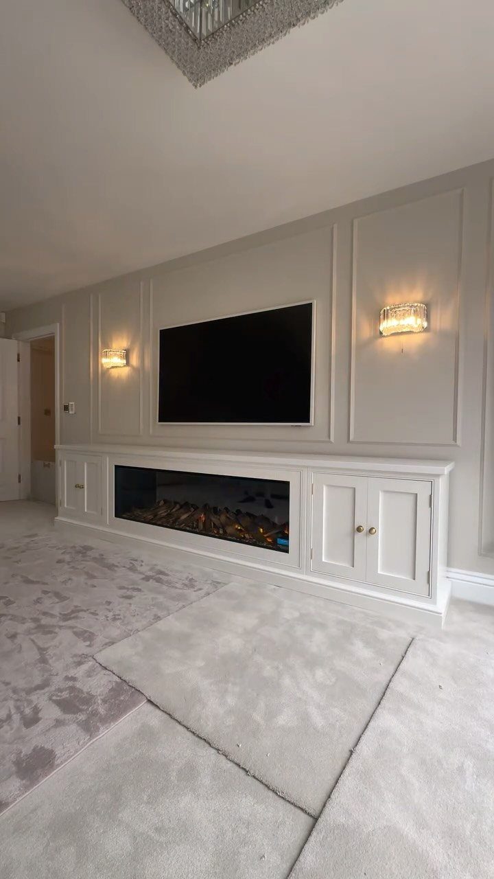 Living Room Storage Cabinet Ideas: 14 Styles That Fit Any Space 8 White built-in storage cabinet with electric fireplace under a wall-mounted television.