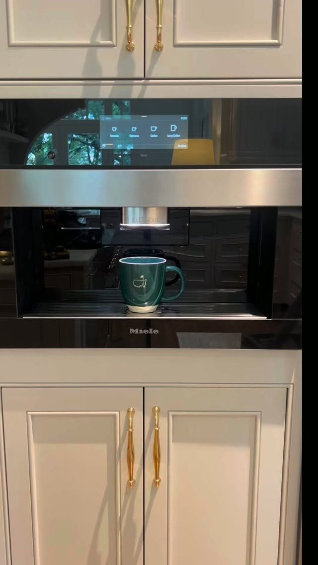 Hidden Coffee Bar Cabinet: 17 Ideas for Every Style 10 Built-in Miele coffee machine integrated into white cabinetry with a green mug.