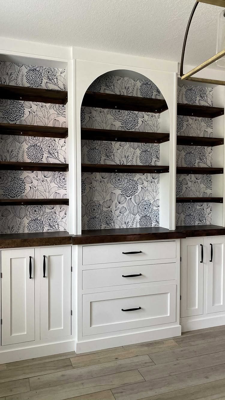 Dining Room Armoire: 16 Ideas for Storage and Style 4 White built-in dining hutch with dark wood shelves and floral wallpaper backing.