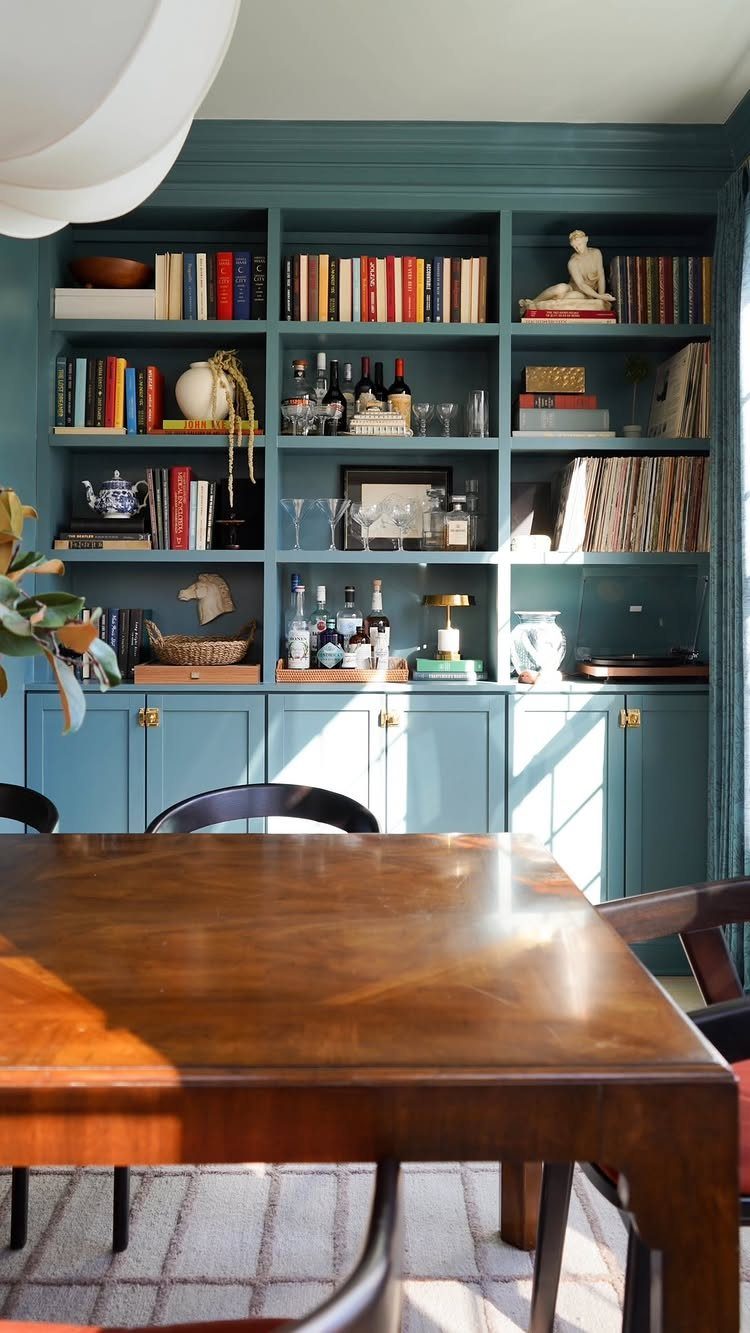 Living Room Storage Cabinet Ideas: 14 Styles That Fit Any Space 9 Teal built-in cabinet bookcase with open shelving and closed bottom cupboards in a dining room.