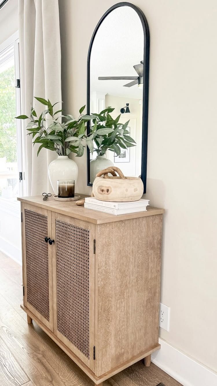 Living Room Storage Cabinet Ideas: 14 Styles That Fit Any Space 11 Light wood cabinet with cane doors and a black arched mirror behind it