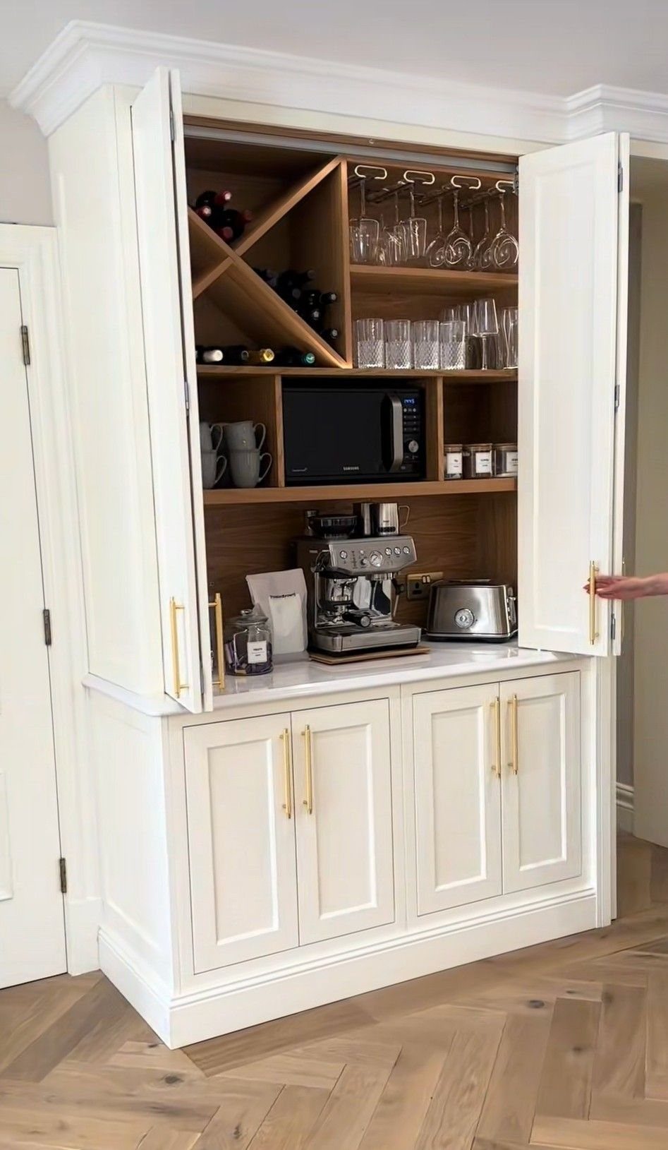 Hidden Coffee Bar Cabinet: 17 Ideas for Every Style 6 White hidden cabinet featuring an espresso machine, wine racks, and hanging glassware holders.