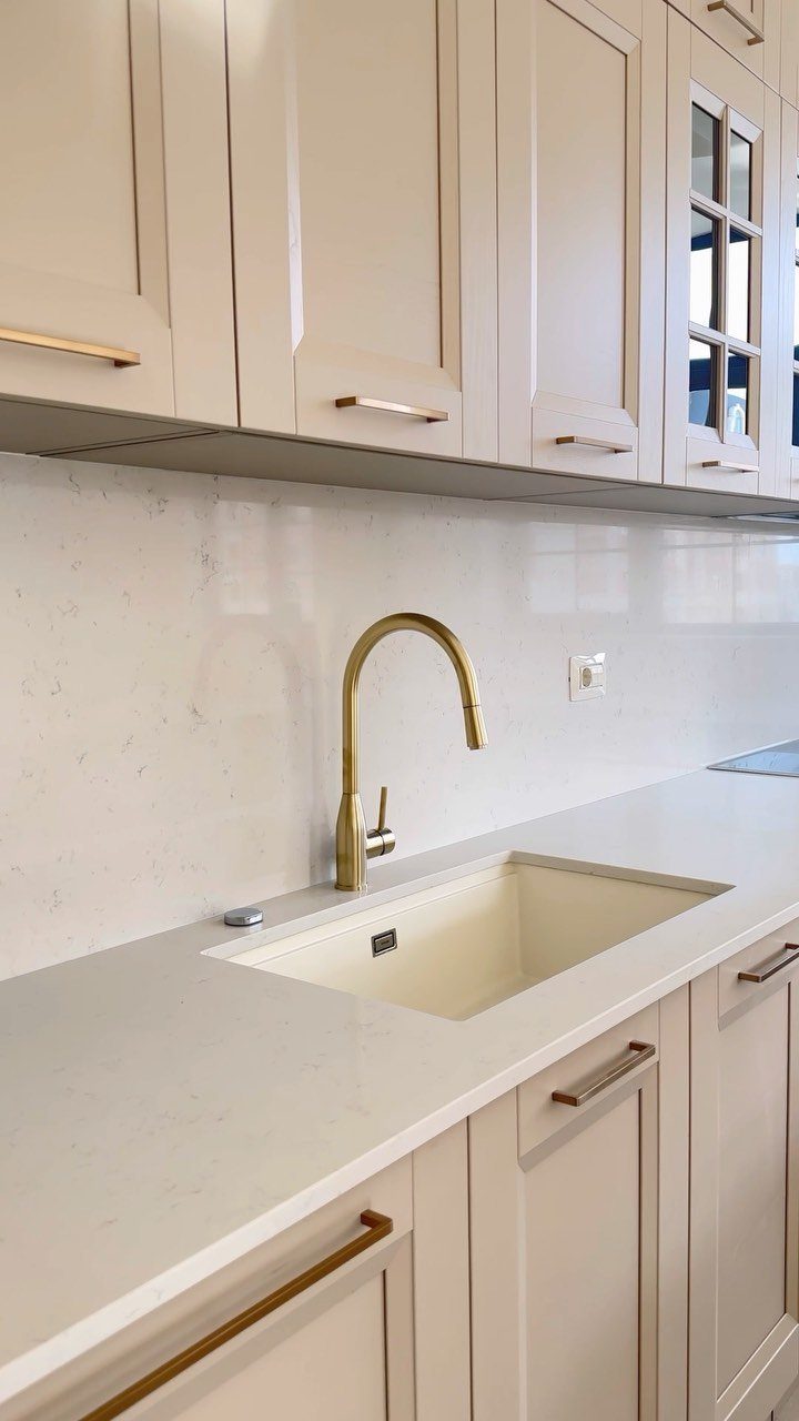 Nigerian Kitchen Design: 25 Ideas for Modern Functional Spaces 19 Modern kitchen with cream shaker cabinets, white quartz countertops, and gold hardware.