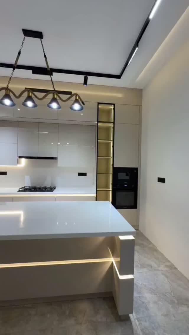 Nigerian Kitchen Design: 25 Ideas for Modern Functional Spaces 11 Modern white kitchen with custom glossy cabinets, a large island, and track lighting.