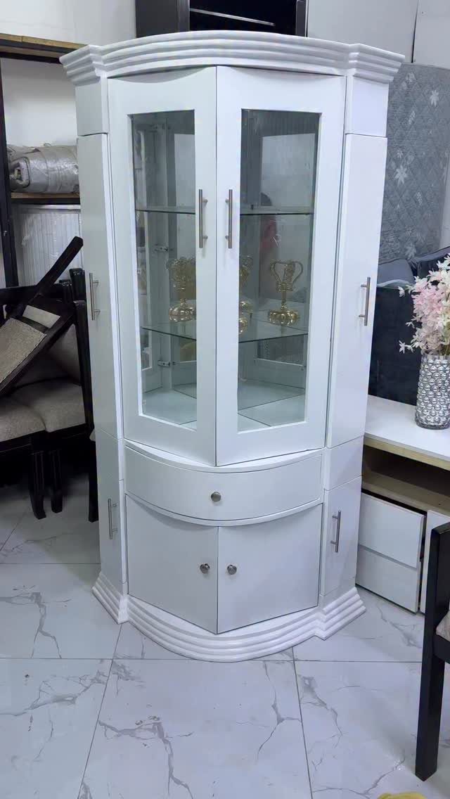 Living Room Storage Cabinet Ideas: 14 Styles That Fit Any Space 7 White wooden display hutch with glass doors and trophies on white tiled floor