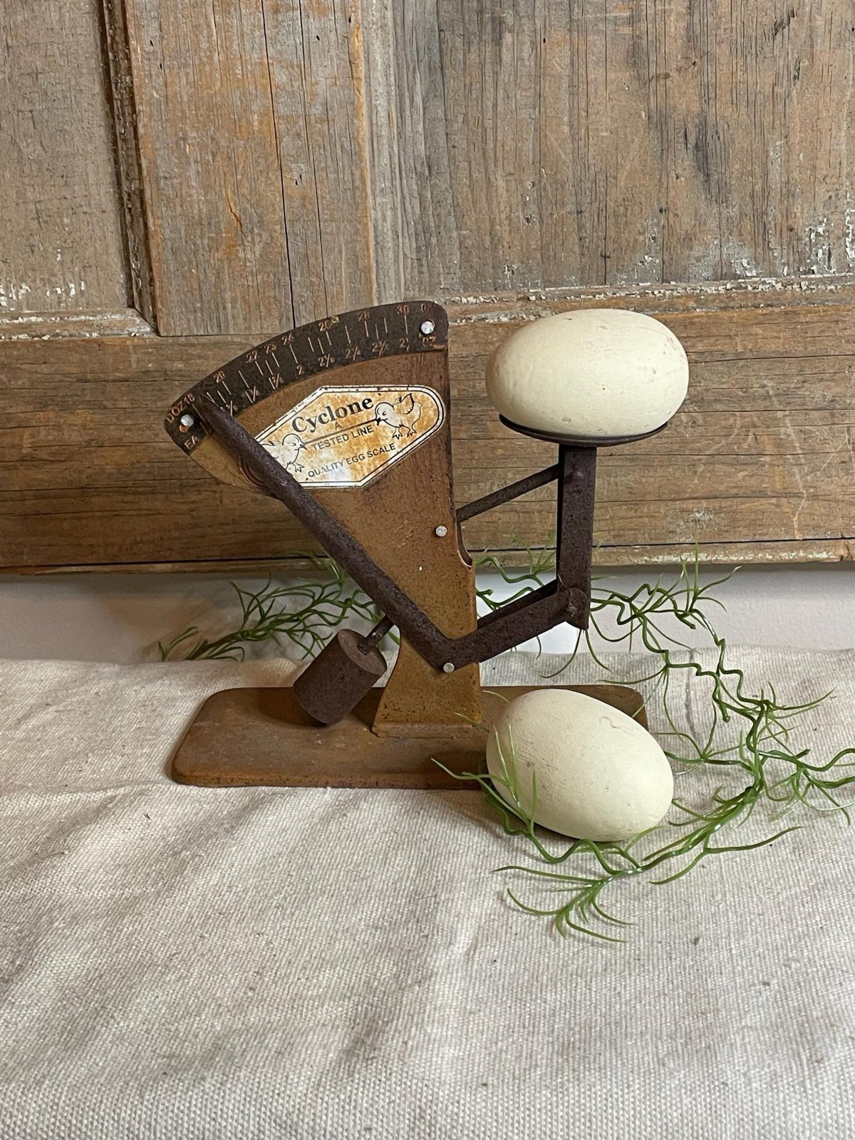 Antique egg grader with white eggs on a linen cloth and wooden background.