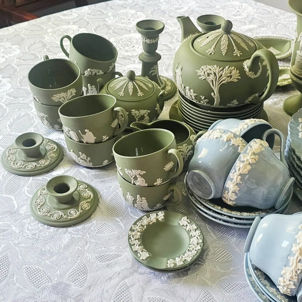 Vintage ceramic tea sets in green and blue with white embossed floral details.