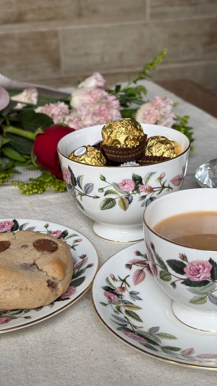 Floral porcelain tea cup, saucer, and bowl with gold rims and pink roses.