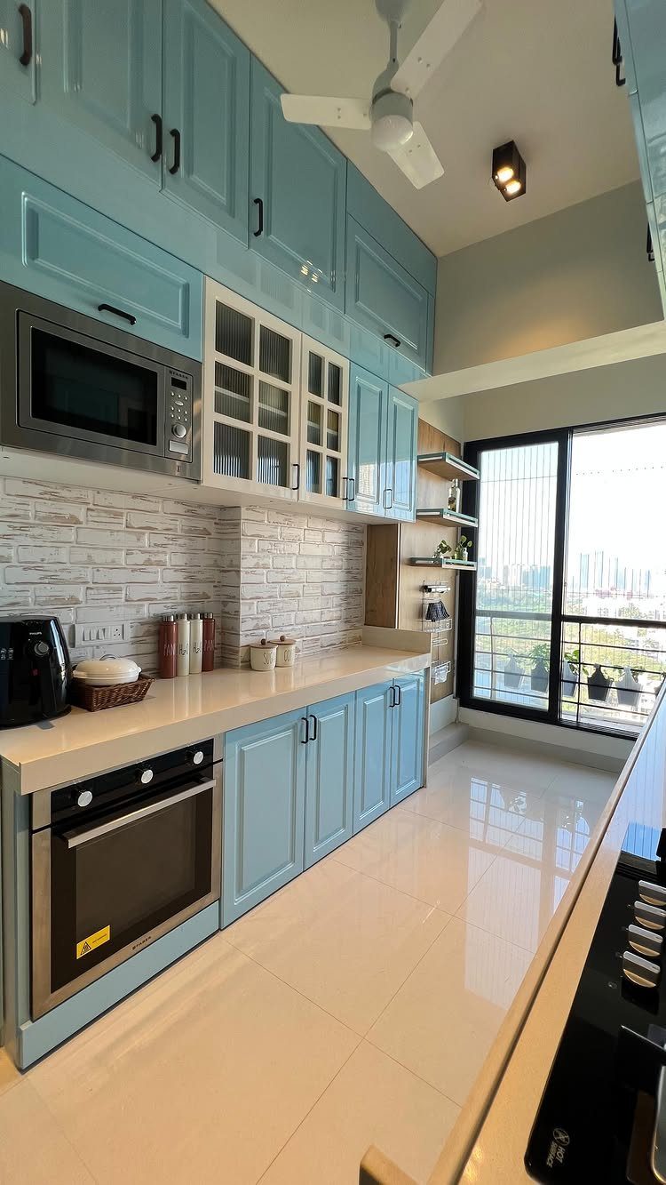 Nigerian Kitchen Design: 25 Ideas for Modern Functional Spaces 3 Galley kitchen with light blue cabinets, cream countertops, and a large window.