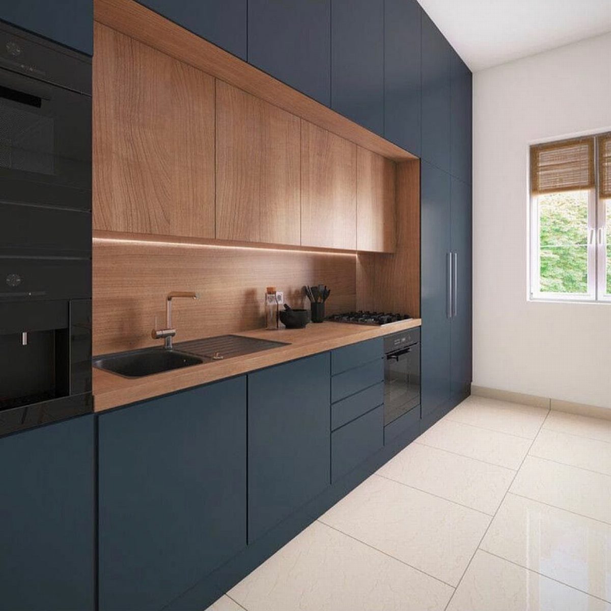 Linear kitchen cabinets in navy blue and light wood with integrated appliances.