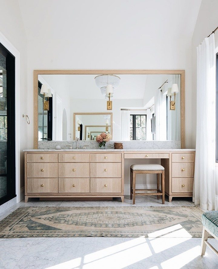 Light wood bathroom vanity with a built-in makeup station and a matching stool.
