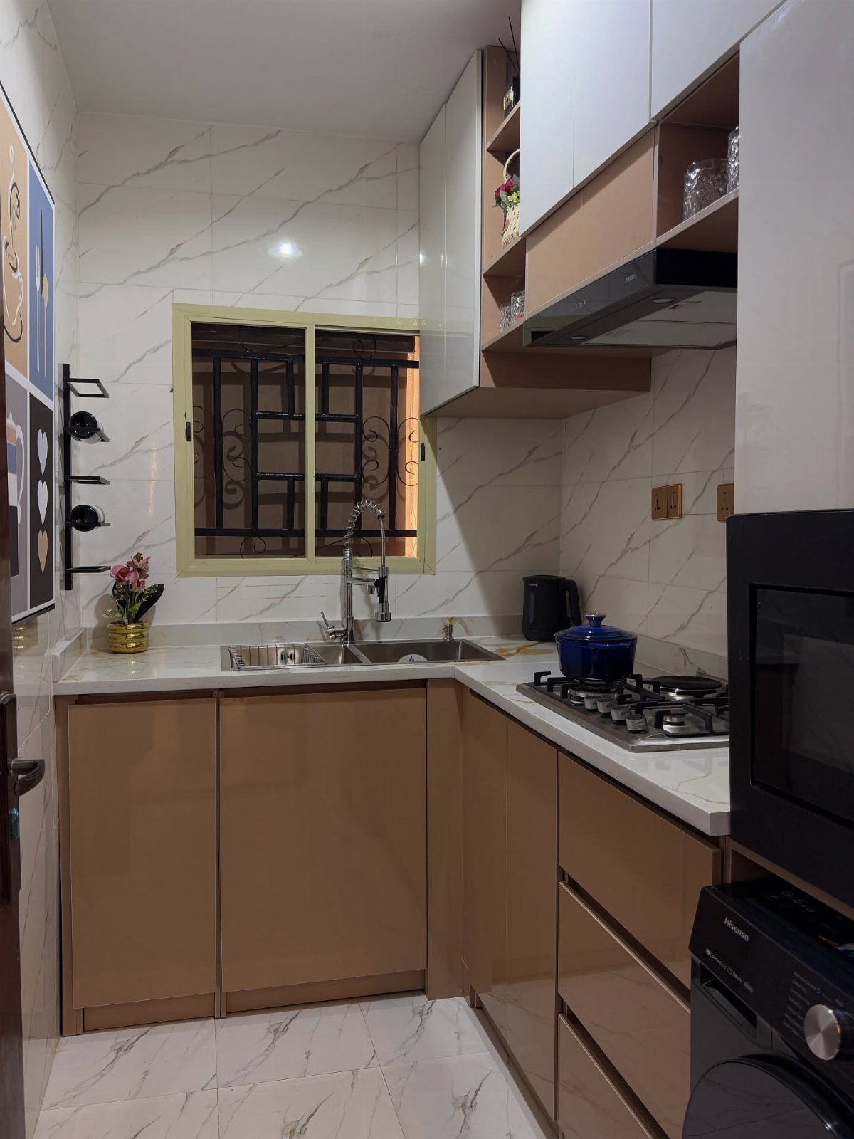 Nigerian Kitchen Design: 25 Ideas for Modern Functional Spaces 13 Modern kitchen with tan cabinets, white countertops, and marble-patterned wall tiles.