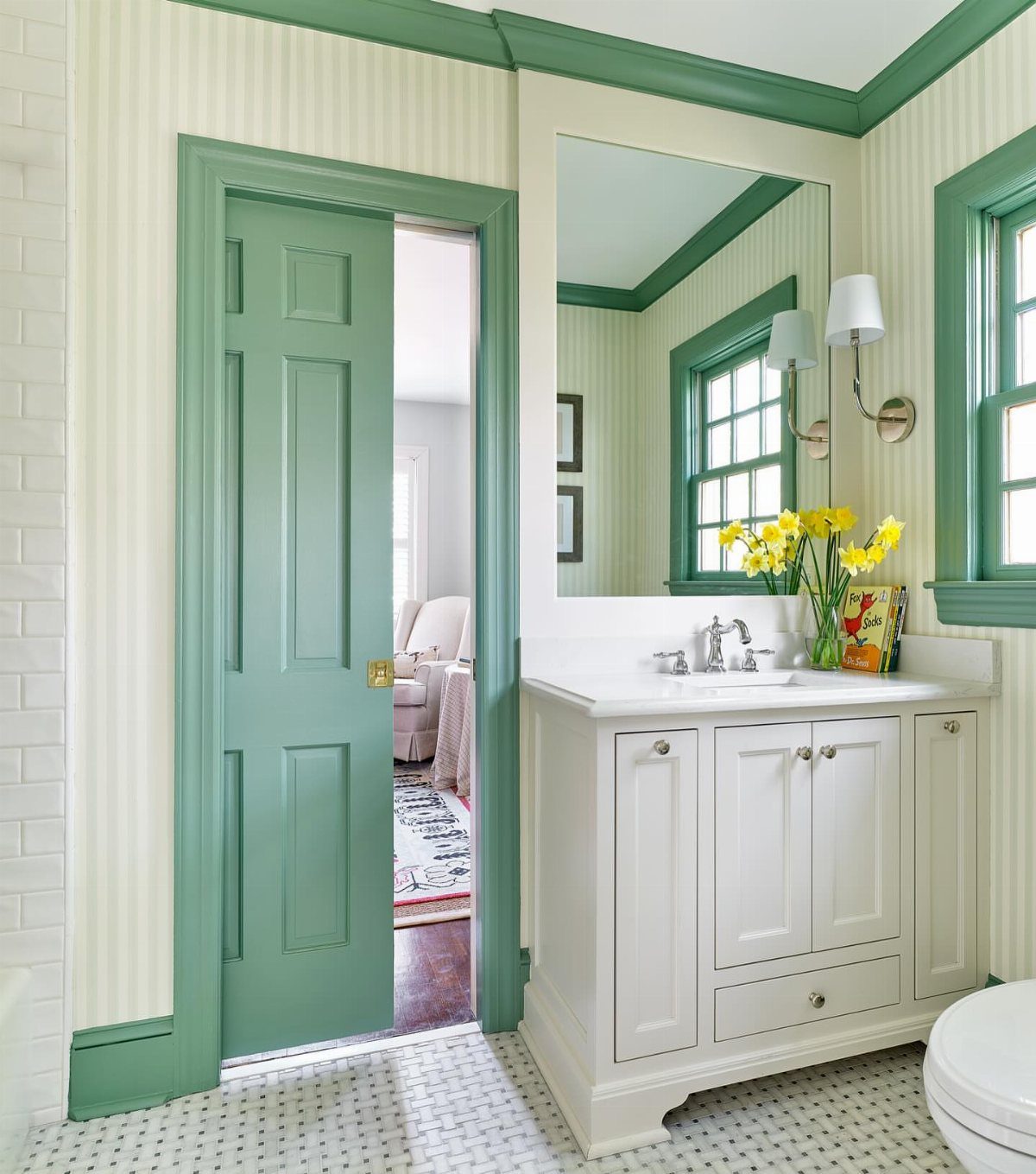 Sage green painted door and trim in a bathroom with white vanity.