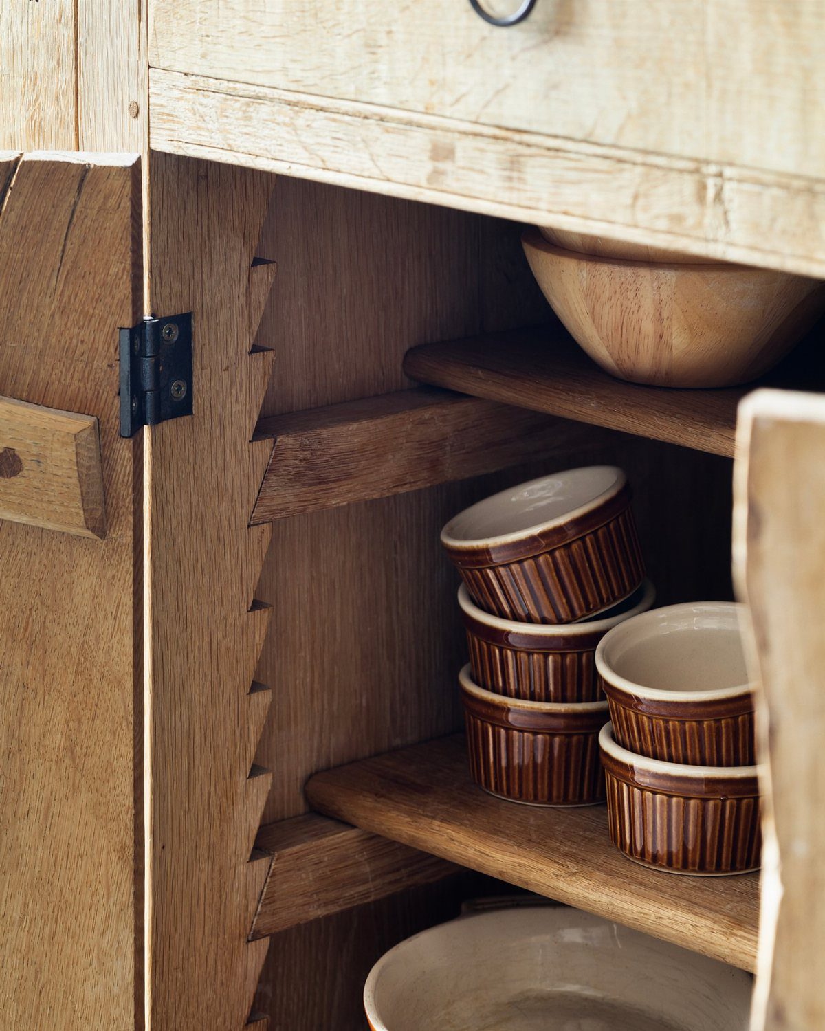 Kitchen Wood Pantry: 40 Ideas with Glass, Drawers, and Doors 39 Wooden pantry shelves supported by notched vertical cleats holding ceramic ramekins and bowls.