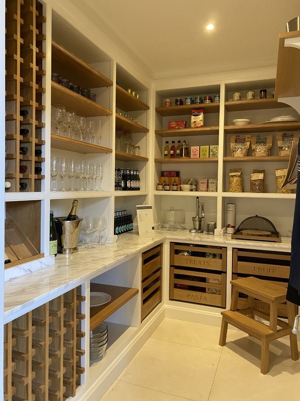 Kitchen Wood Pantry: 40 Ideas with Glass, Drawers, and Doors 20 White walk-in pantry with built-in wooden wine cubbies and marble countertops.