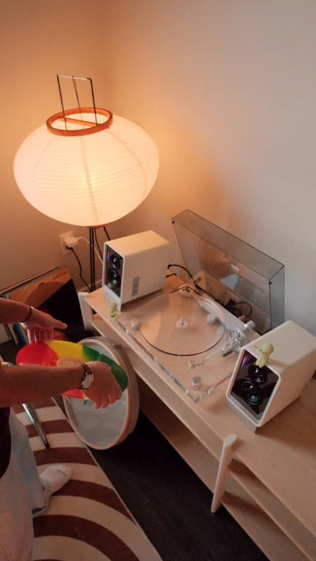 White spherical paper lantern lamp lighting a wooden table with electronic equipment