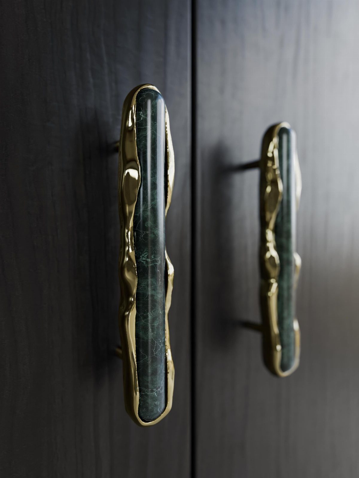 Polished gold cabinet handles with green marble insets on black doors