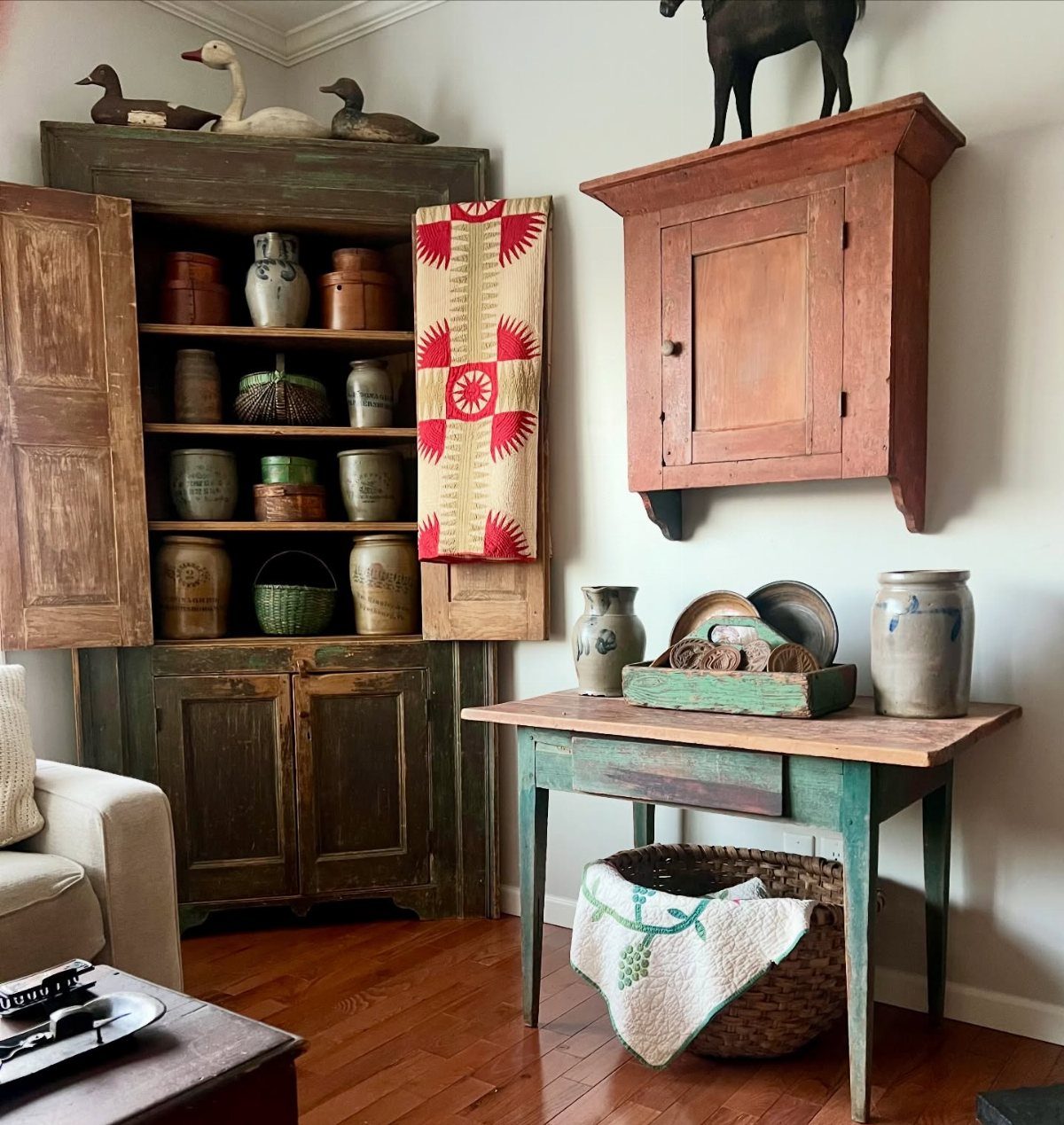 Rustic wooden hutch and cabinets with pottery in a farmhouse style interior setting.