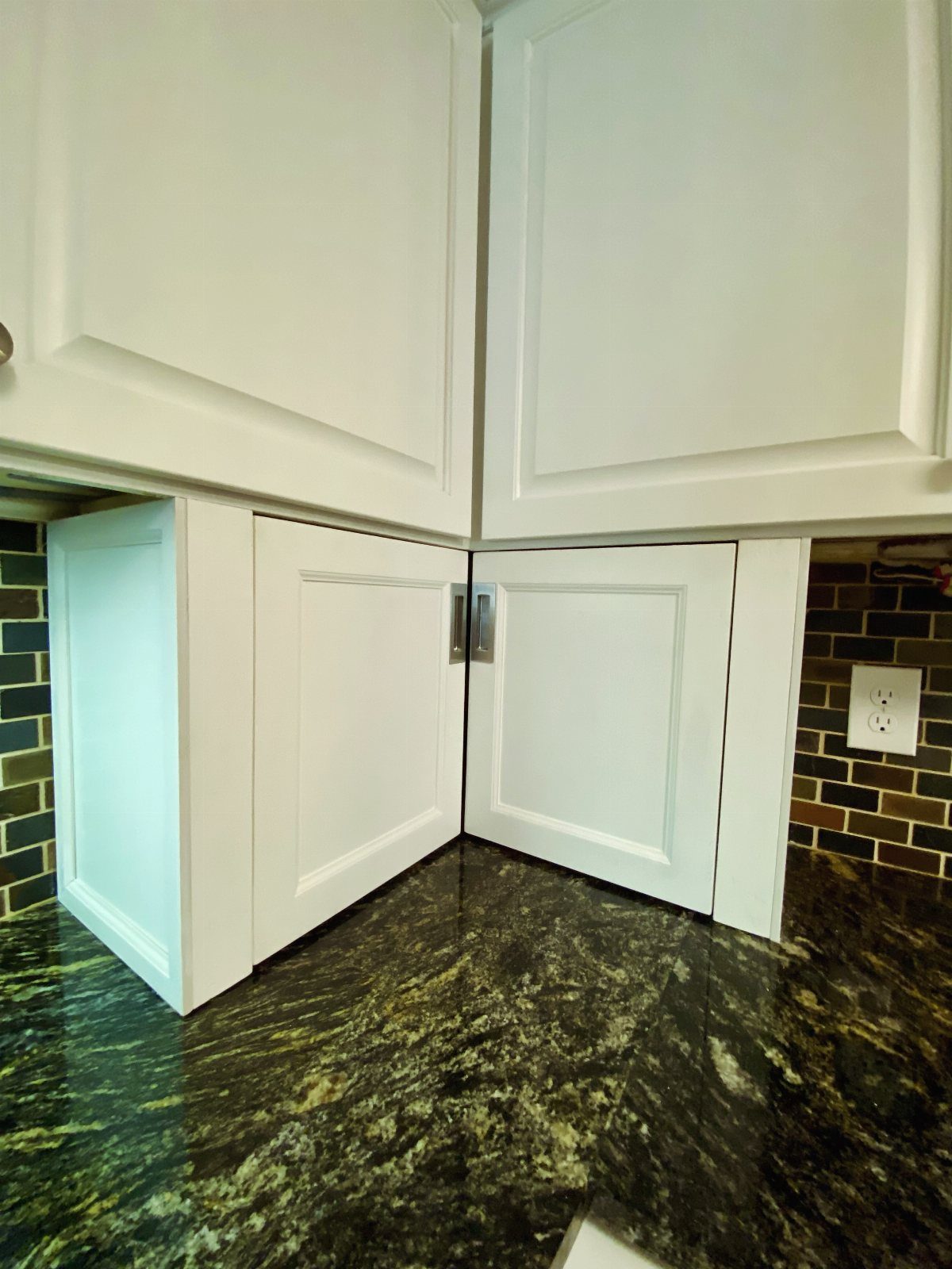 12 Kitchen Cabinet Handles Ideas to Refresh Your Space 8 Silver recessed pull handle on white kitchen cabinets with dark granite countertops