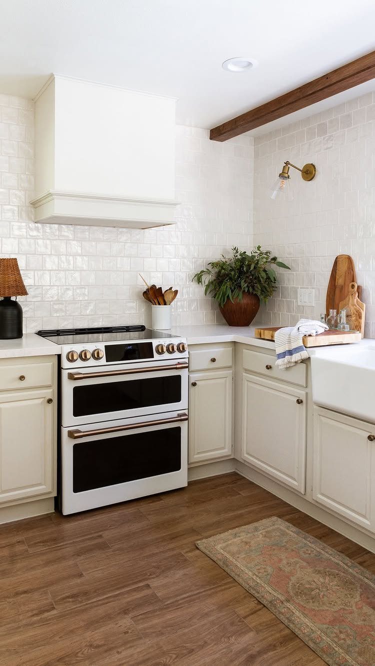 White lower kitchen cabinets and tiled backsplash with open wall space above the counter.