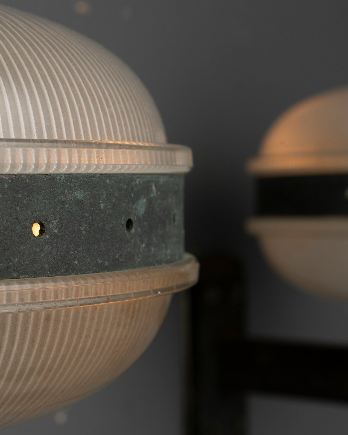 Mid-century modern wall sconce with ribbed white glass and dark metal band.