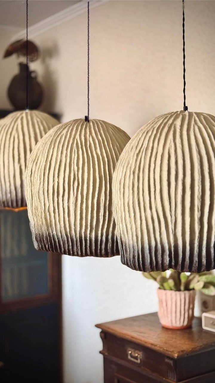 Three ribbed cream and brown gradient pendant lamps hanging in a cozy room.