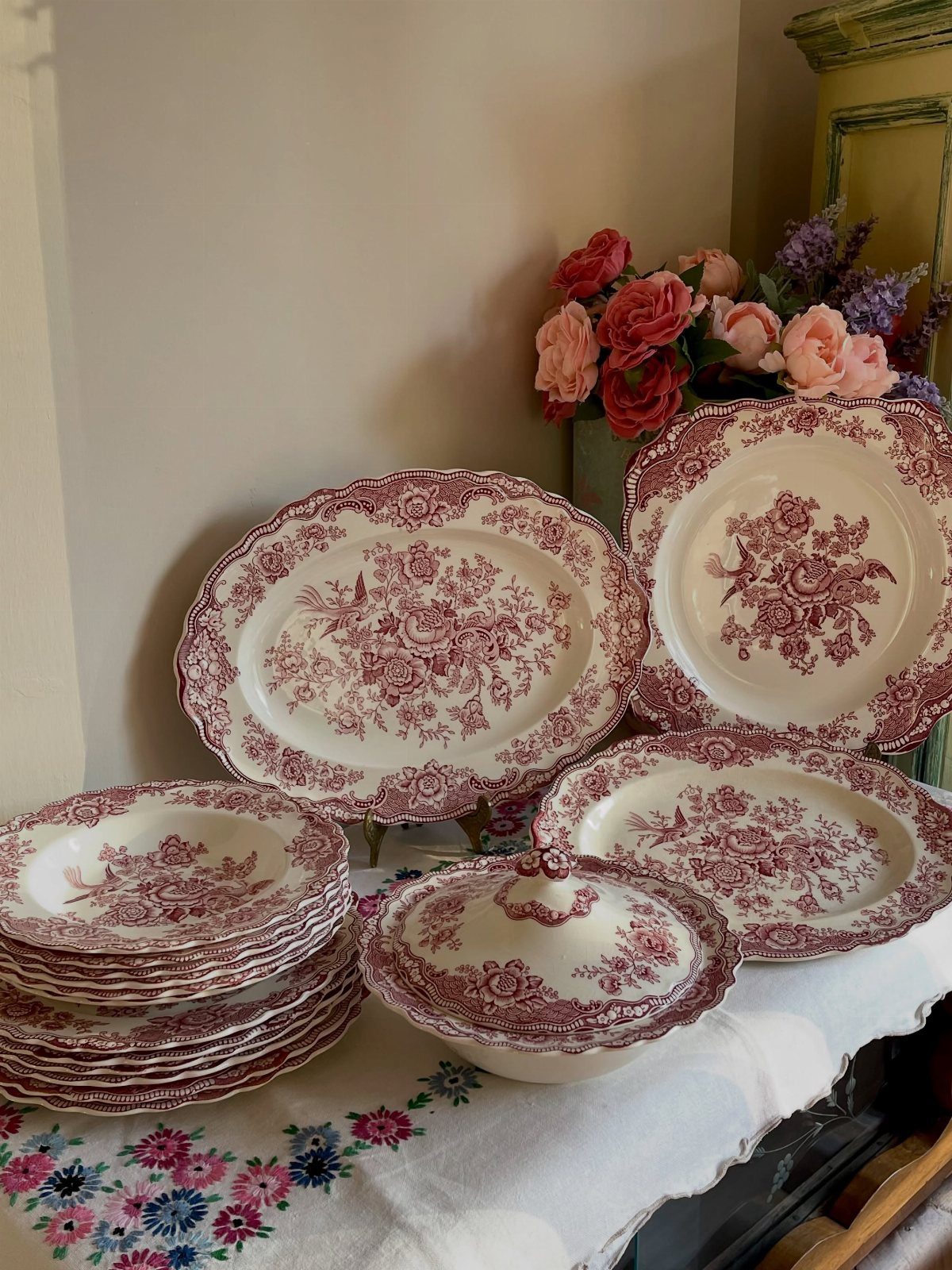Vintage Plate Set Ideas: 12 Timeless Styles for Your Table 5 Burgundy floral chintz porcelain plates and platter arranged on a white lace tablecloth.