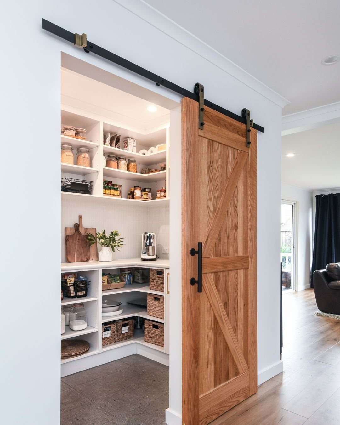 Kitchen Wood Pantry: 40 Ideas with Glass, Drawers, and Doors 37 Rustic wood barn door sliding open to a white organized kitchen pantry.