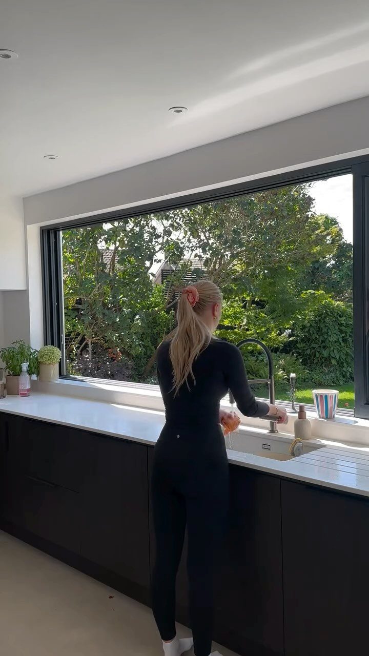 Small Kitchen Sink Ideas: 26 Ways to Maximize Space and Style 13 Kitchen sink located beneath a large window with a view of green trees.