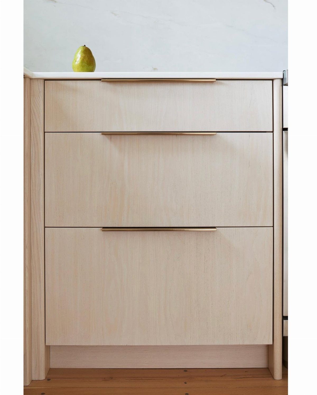 12 Kitchen Cabinet Handles Ideas to Refresh Your Space 5 Light wood kitchen drawers with sleek, minimal gold horizontal metal handles.