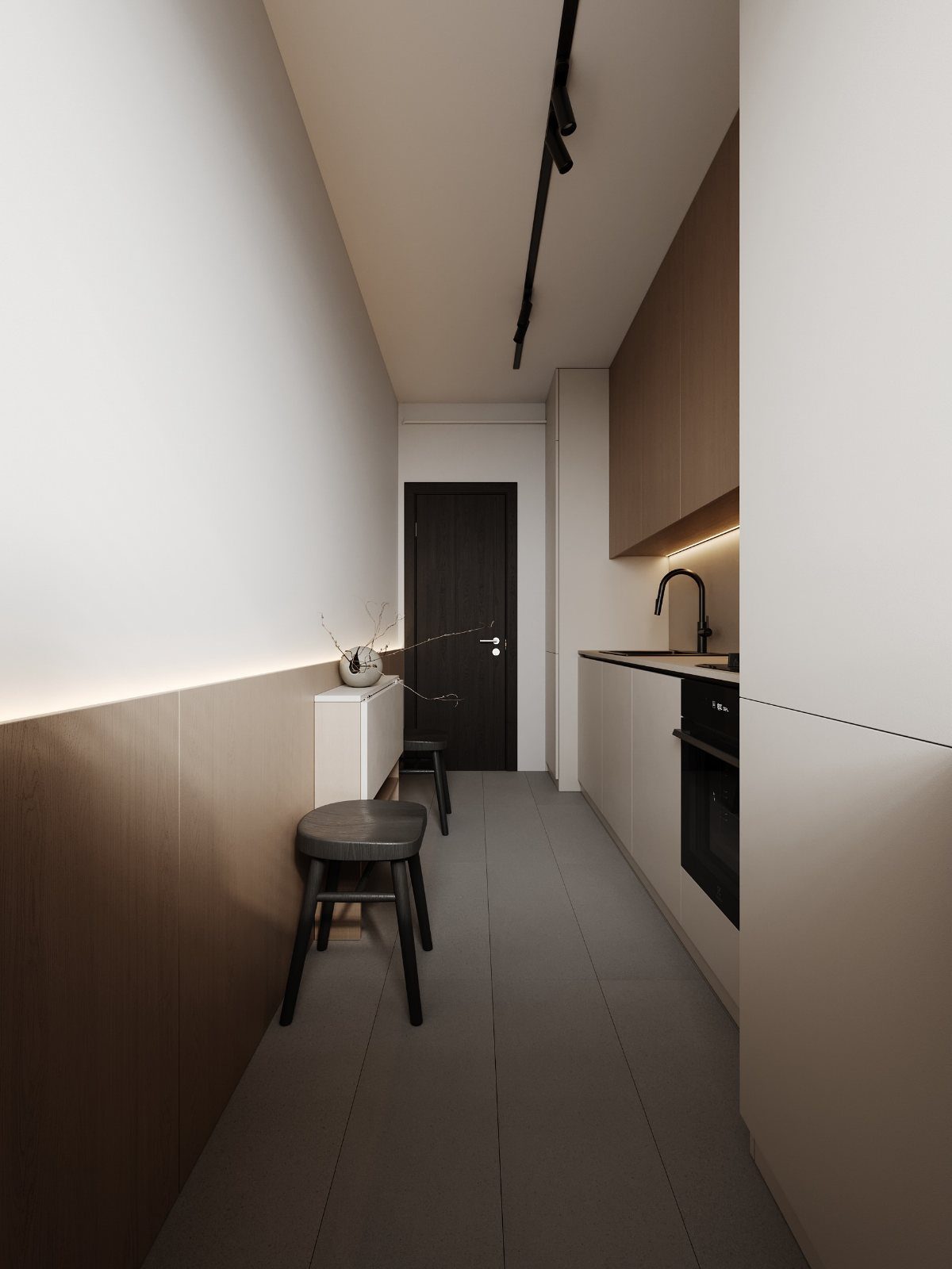 Small kitchen units with white cabinets and black countertops in a narrow modern corridor.