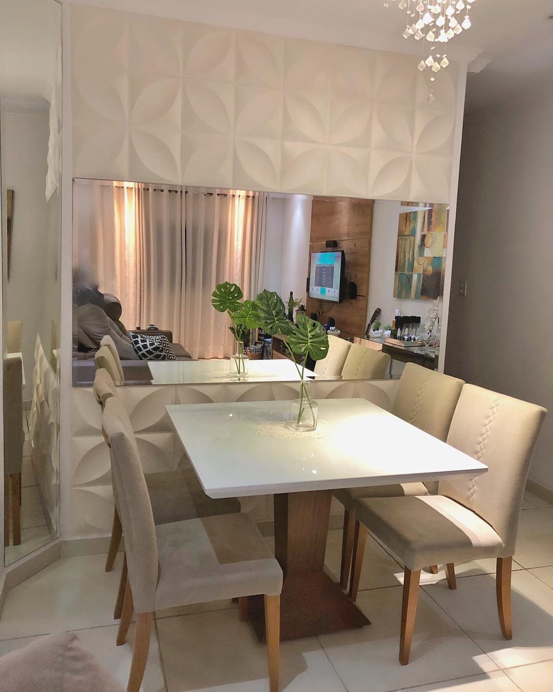 White square dining table with beige chairs in a modern room with textured walls.