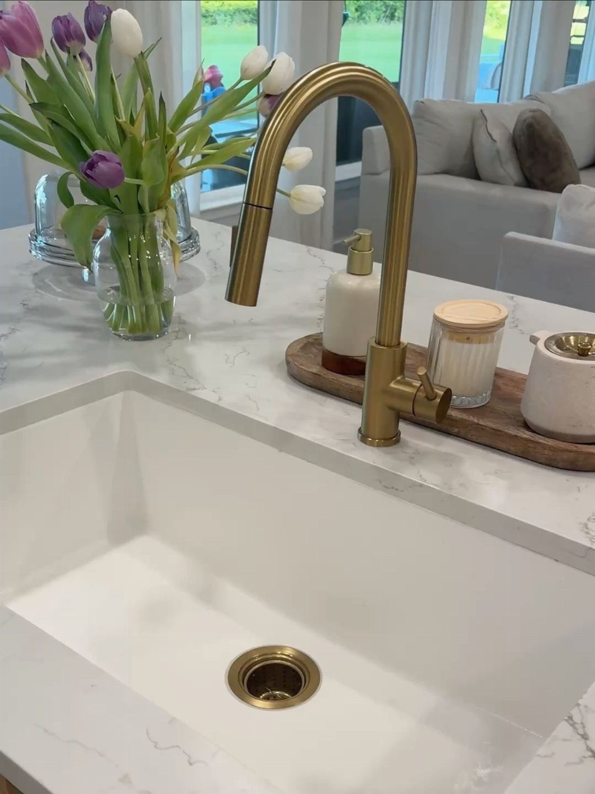Small Kitchen Sink Ideas: 26 Ways to Maximize Space and Style 4 White undermount kitchen sink with a gold faucet and gold drain on marble countertop