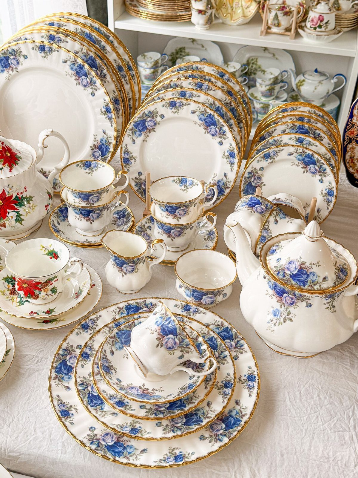 Vintage white porcelain plate set with blue floral patterns and gold gilded edges.