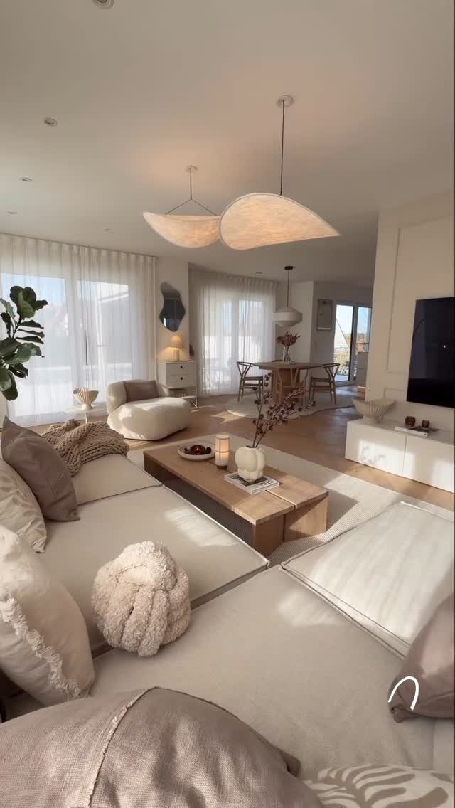 Minimalist living room with beige furniture, light wood accents, and a warm neutral palette.
