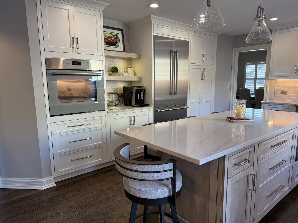 White kitchen island with marble countertop and grey base in a modern kitchen.