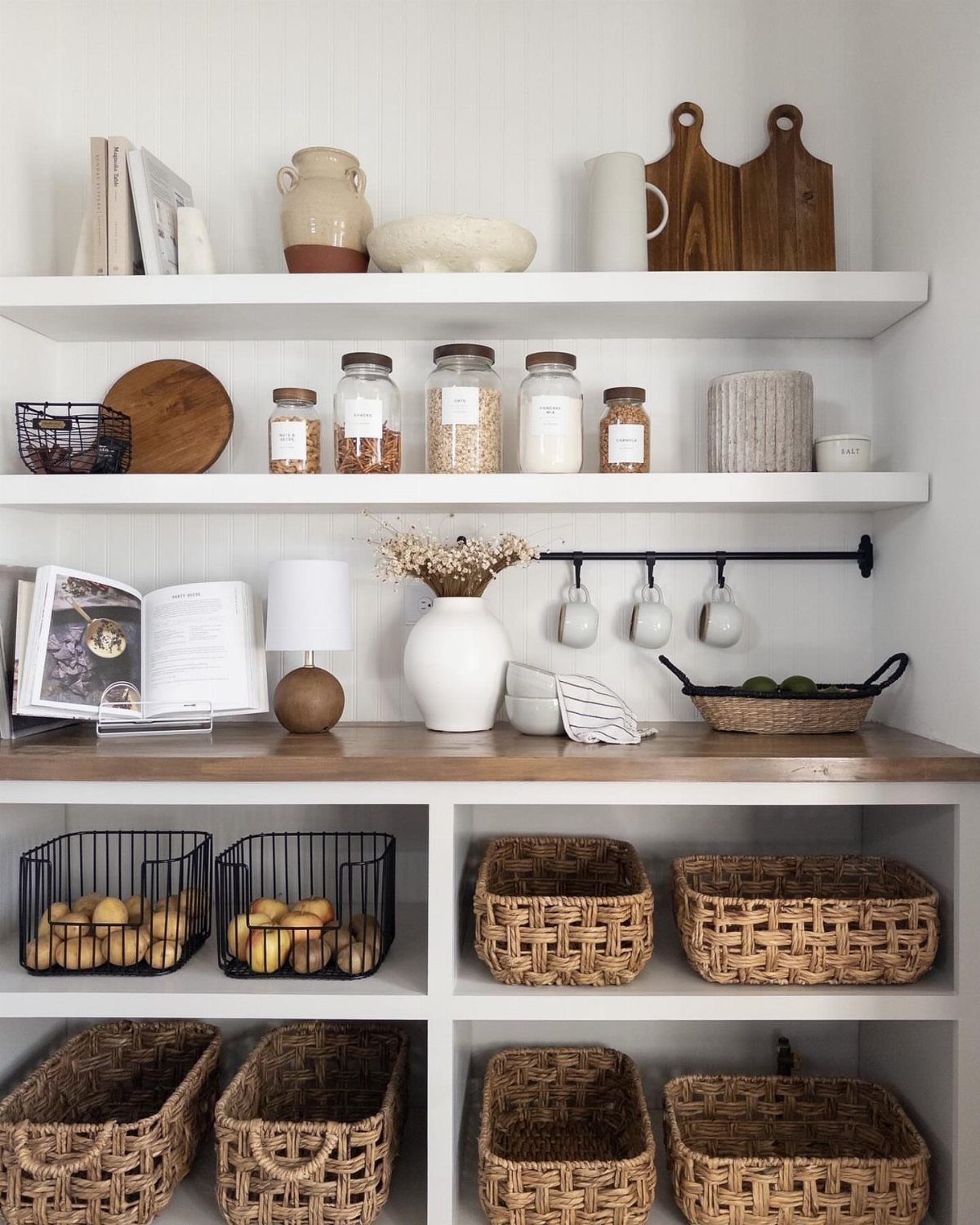 Kitchen Wood Pantry: 40 Ideas with Glass, Drawers, and Doors 3 Woven wicker baskets and wire bins stored on open white pantry shelves.