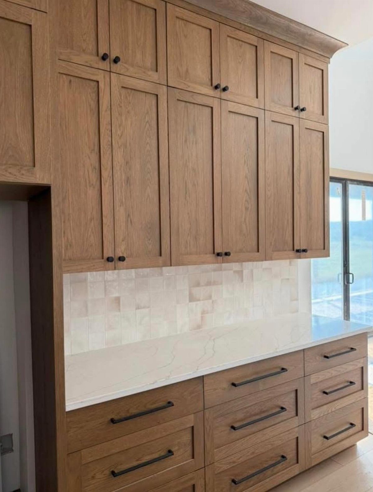 Kitchen Wood Pantry: 40 Ideas with Glass, Drawers, and Doors 27 Light wood pantry cabinets with a white quartz countertop and tiled backsplash.